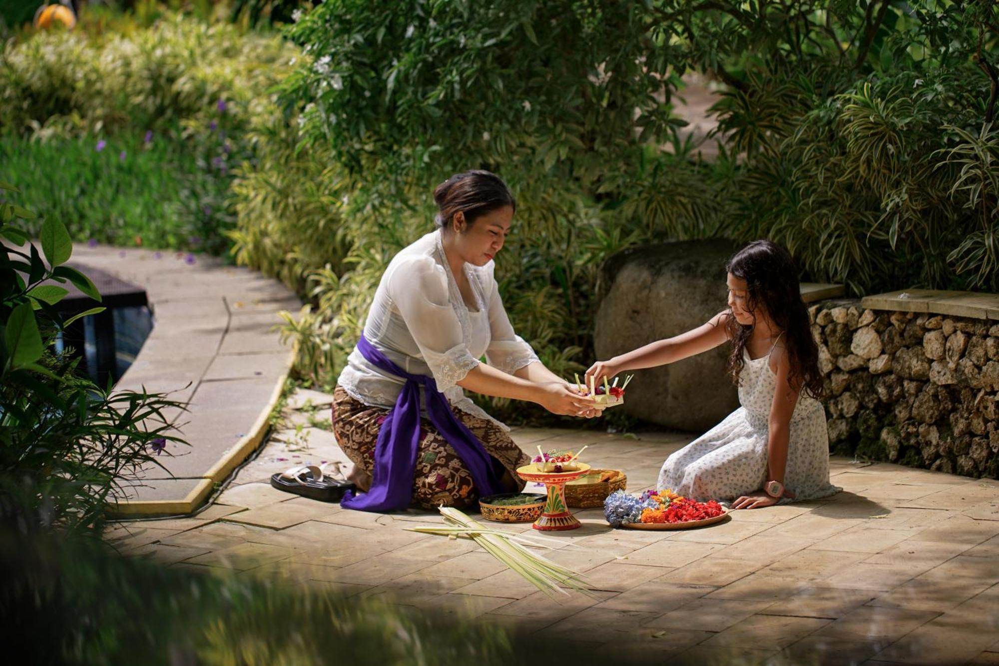 Royal Tulip Springhill Resort Jimbaran Экстерьер фото A woman and a child performing a Hindu ritual